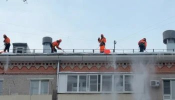 Столичные специалисты проводят очистку крыш жилых домов после снегопада