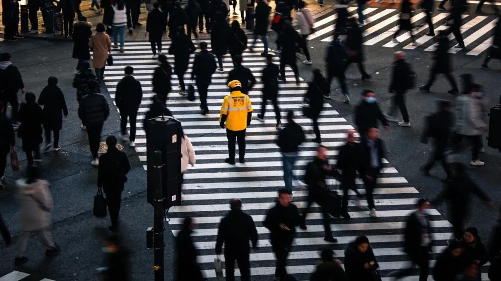 Пеший курьер с рюкзаком-термосом проверяет маршрут в мобильном приложении на смартфоне.